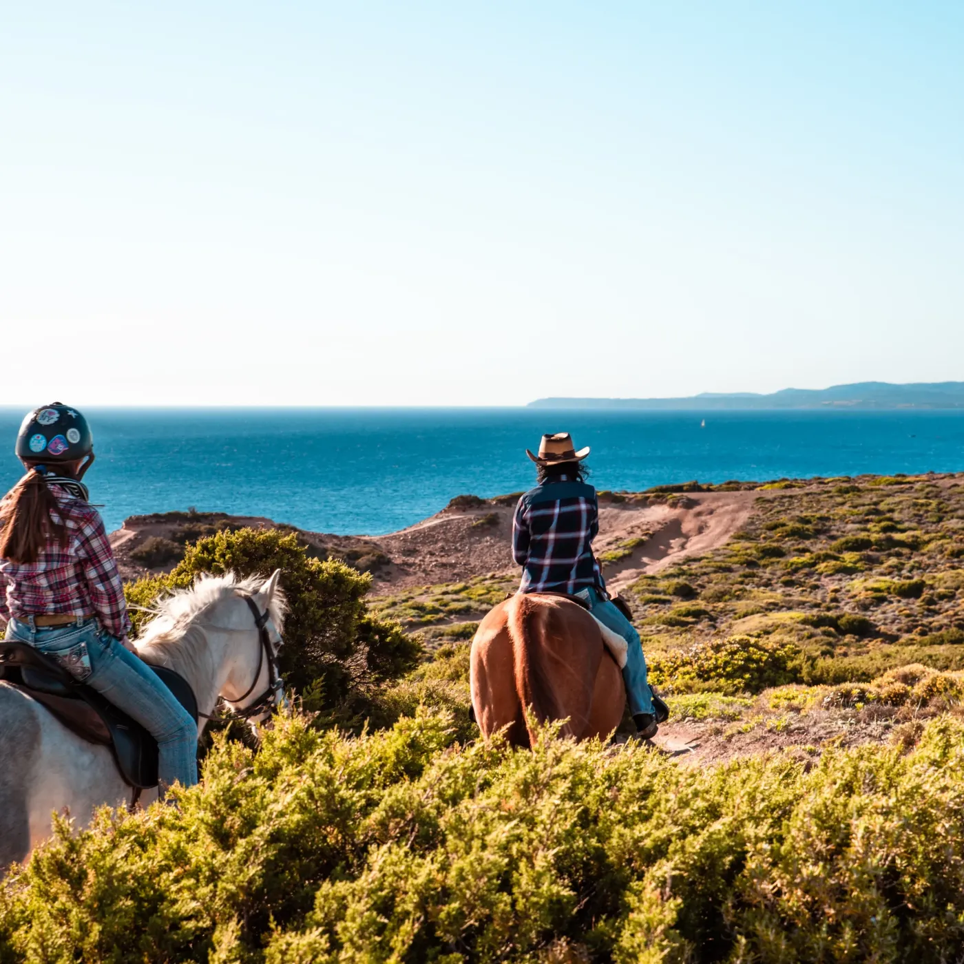 Riders above the sea on the Arco dei Baci horse ride, Sant'Antioco